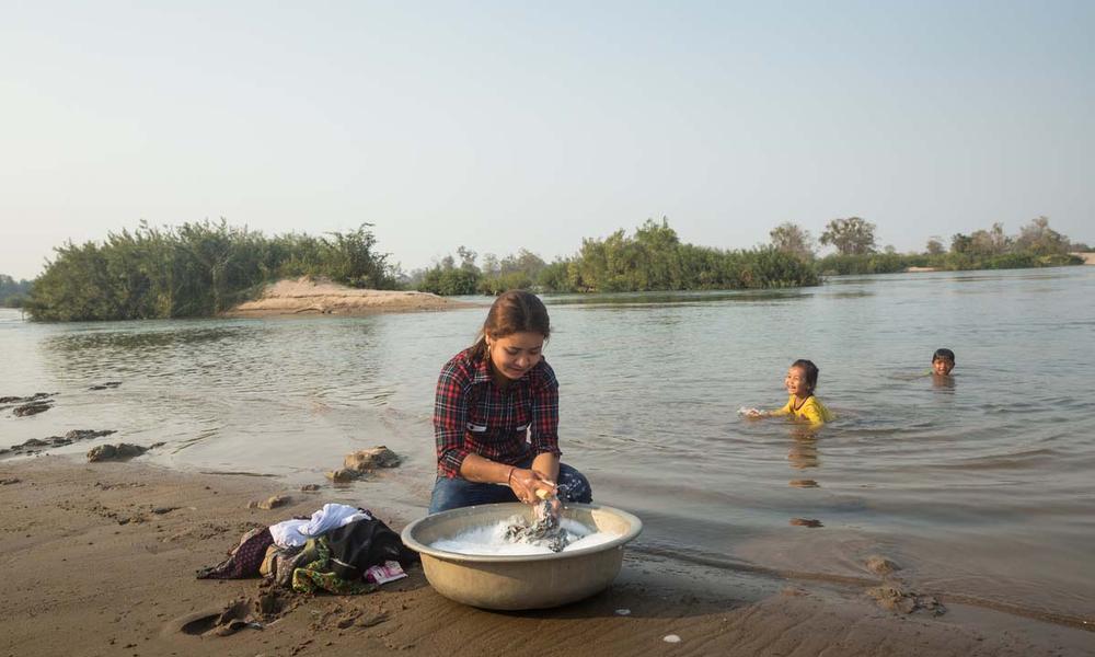Vutra washes clothing in river