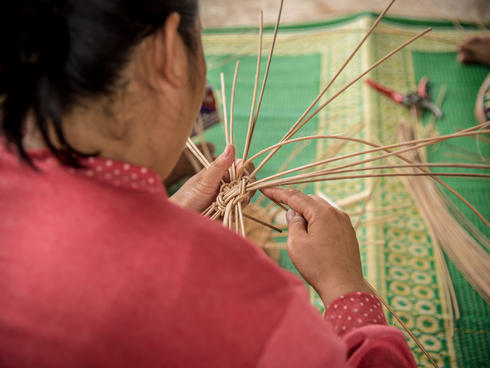 A woman basket weaving.