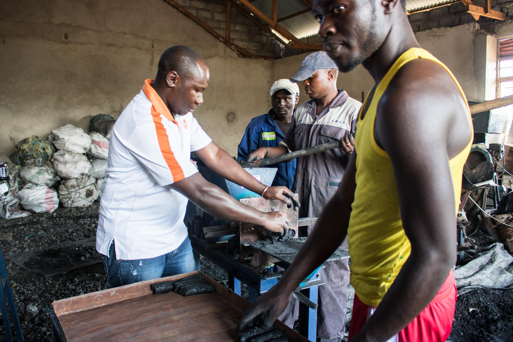 Men making stove briquettes