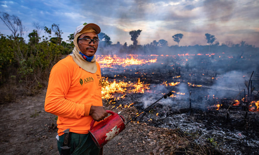 Man in front of burning ground