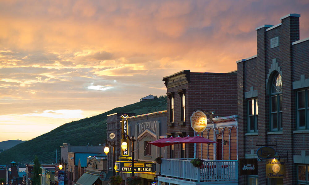 Glowing storefronts amid a pink sunset.