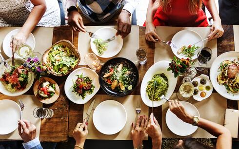 aerial shot of a group of people sitting around a table sharing a meal