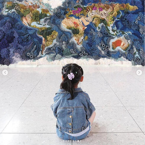 Photo of girl seated looking at mural