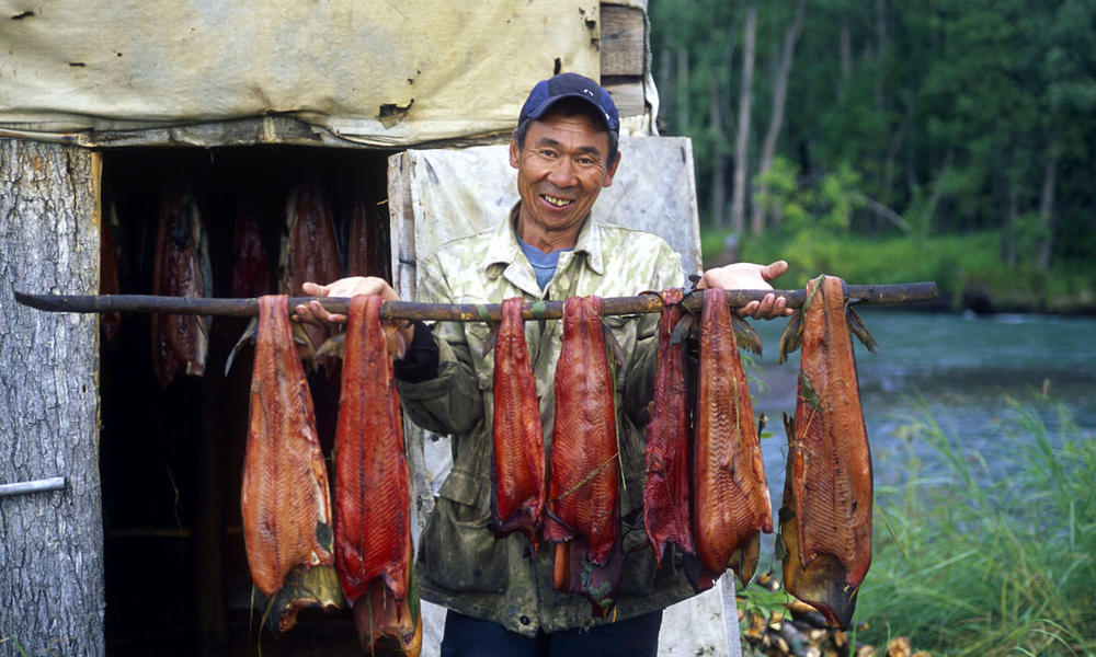 kamchatka salmon fisherman in front of smoking cabin